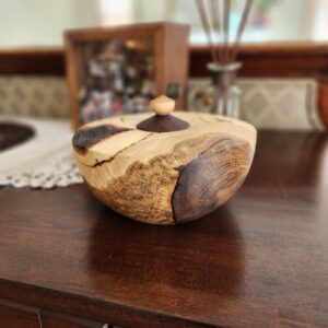 Handcrafted white oak pet urn with natural bark inclusion and lid, designed to hold up to 55 cubic inches.